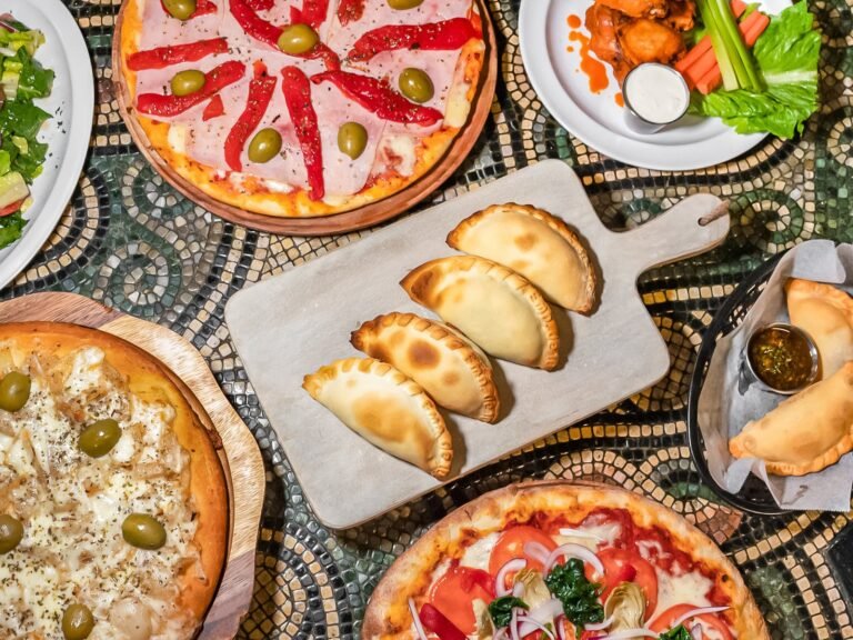 deliciosas pizzas y empanadas sobre una mesa