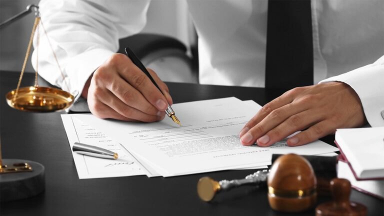 escribano firmando documentos en su oficina