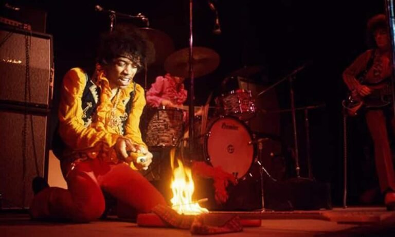 jimi hendrix tocando guitarra en el escenario