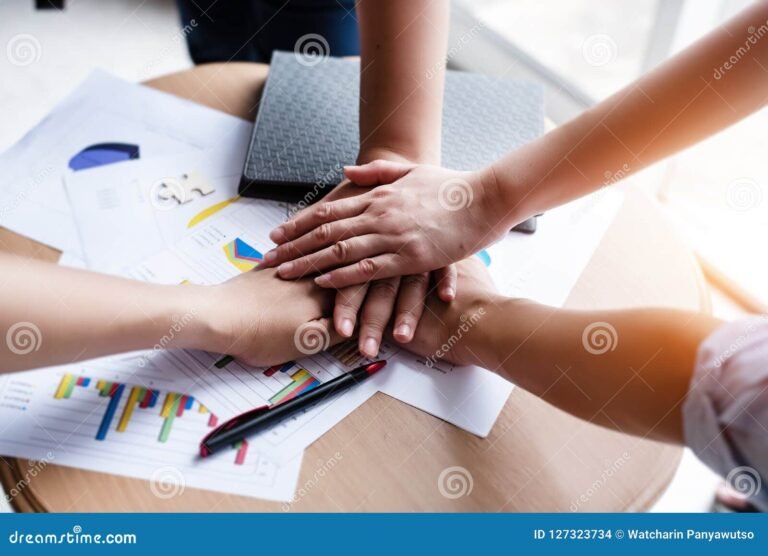 manos colaborando sobre un plano de negocio