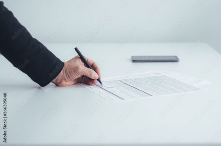 manos firmando un contrato en la mesa