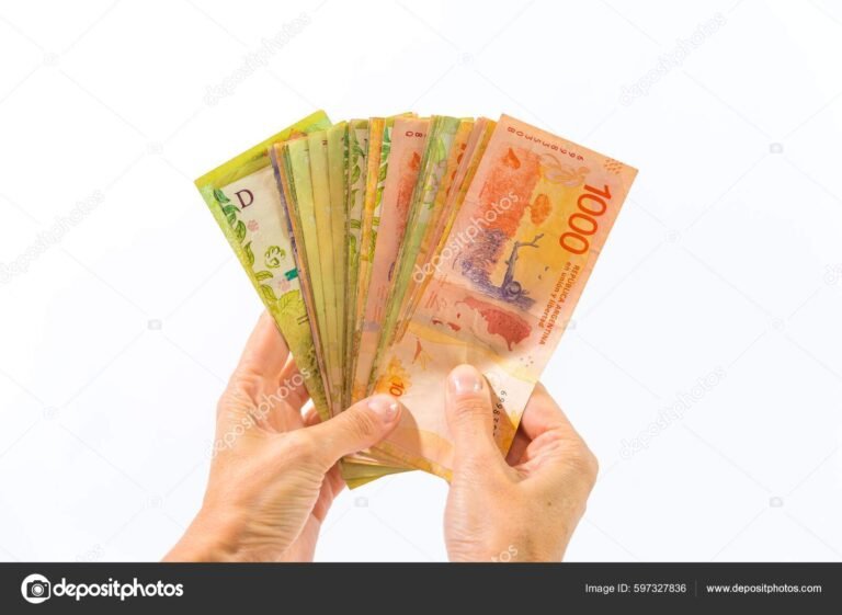 manos sosteniendo billetes y monedas argentinas