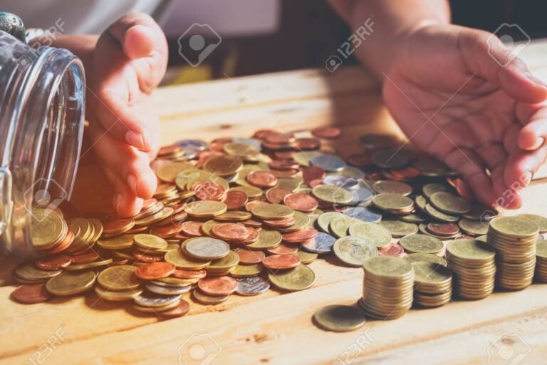 manos sosteniendo monedas sobre una mesa