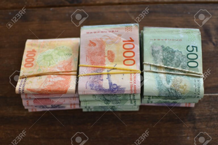 monedas y billetes argentinos en una mesa