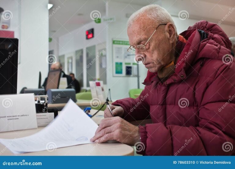 persona firmando documentos en un banco