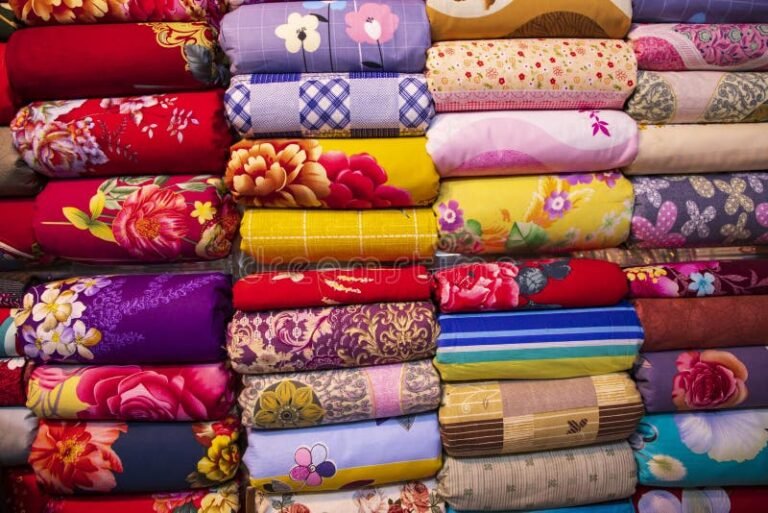 Dónde encontrar sábanas por mayor en Flores, Buenos Aires 12 sabanas apiladas en una tienda de textiles