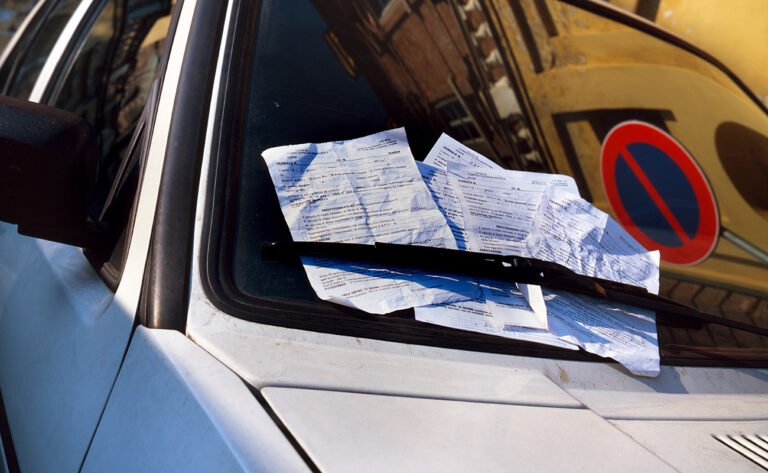 vehiculo estacionado con multa en el parabrisas